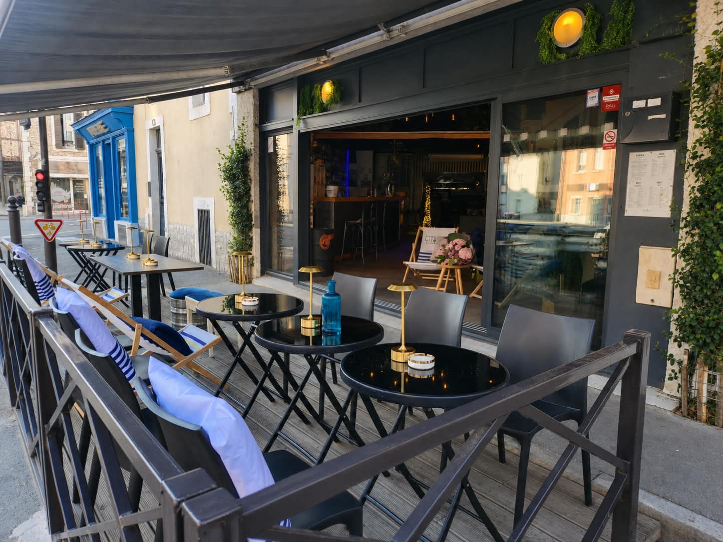 Terrasse extérieure d'Œno Bar, tables et chaises sur le trottoir de Pau
