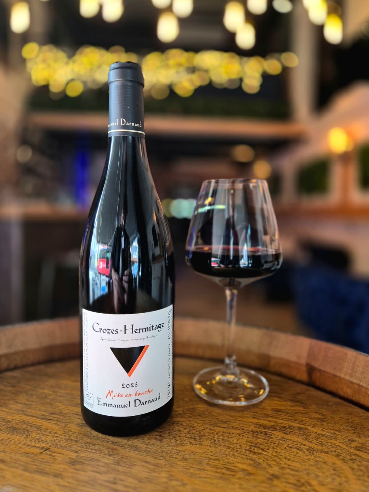 Bouteille Crozes-Hermitage et verre de vin rouge sur une table en bois